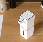 USB rechargeable automatic foam soap dispenser in white with green soap level indicator on wooden desk