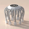 White octopus electric head massager with gray arms and white massage tips, touch control panel on top, on beige background