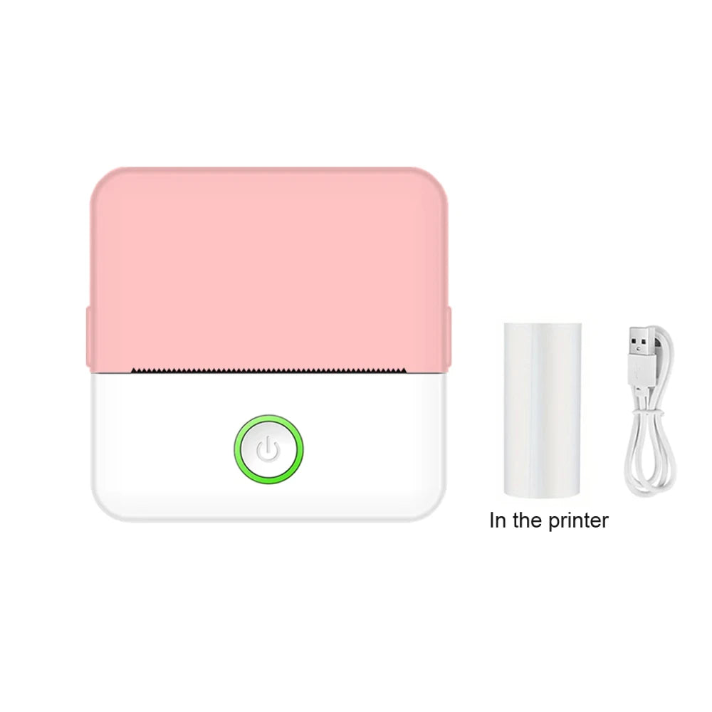 Pink portable thermal pocket printer with thermal paper roll and USB charging cable on white background