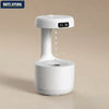 Anti-gravity ultrasonic air humidifier with LED clock display and floating water droplet effect on beige background