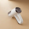 Portable vacuum garment steamer with ergonomic handle and control panel on beige background