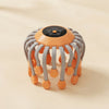 Orange octopus electric head massager with gray flexible arms and orange massage tips, touch control panel on top, on beige background
