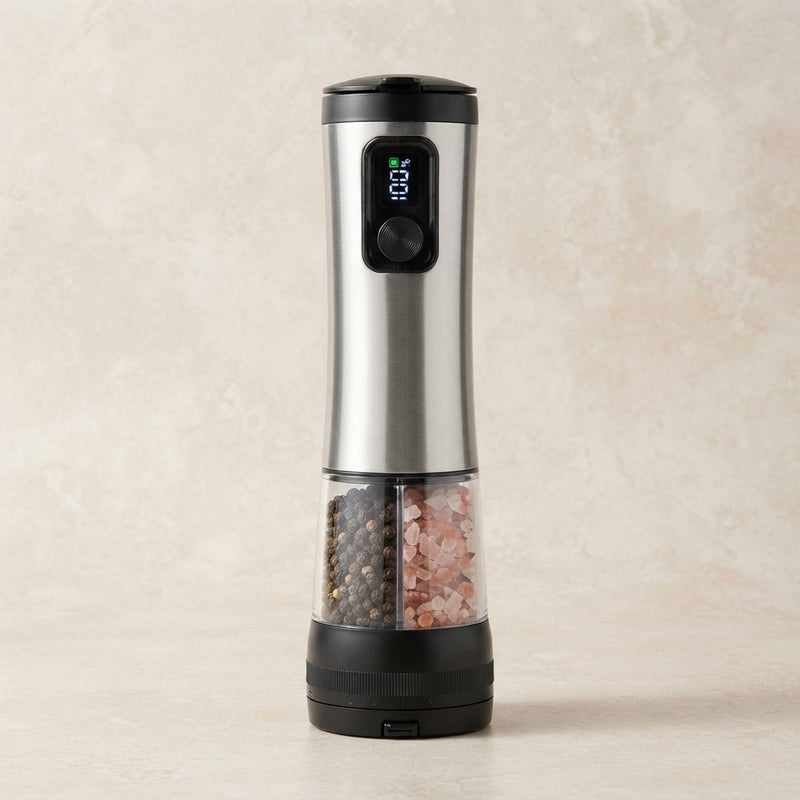 Rechargeable automatic salt and pepper grinder: single stainless steel unit with dual-chamber transparent base holding peppercorns and pink himalayan salt, LED display showing battery level, USB-C charging port, on beige background