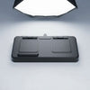 Foldable magnetic wireless charging station in flat/folded position showing two square charging pads and center hinge with USB-C port, on grey background under studio lighting
